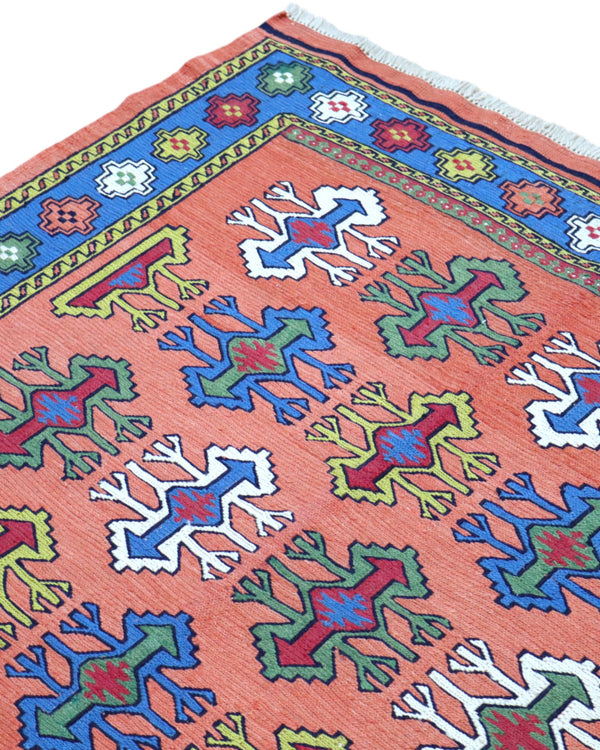 Tappeto Kilim Persia 166x120 cm tessuto a mano, con motivi geometrici multicolore su fondo arancio e bordo blu.