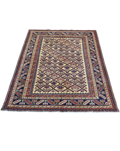 Tappeto Shirvan 166x120 cm in lana annodata a mano, fondo chiaro con rombi geometrici e cornici caucasiche.