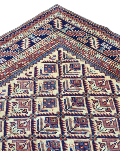 Tappeto Shirvan 166x120 cm in lana annodata a mano, fondo chiaro con rombi geometrici e cornici caucasiche.