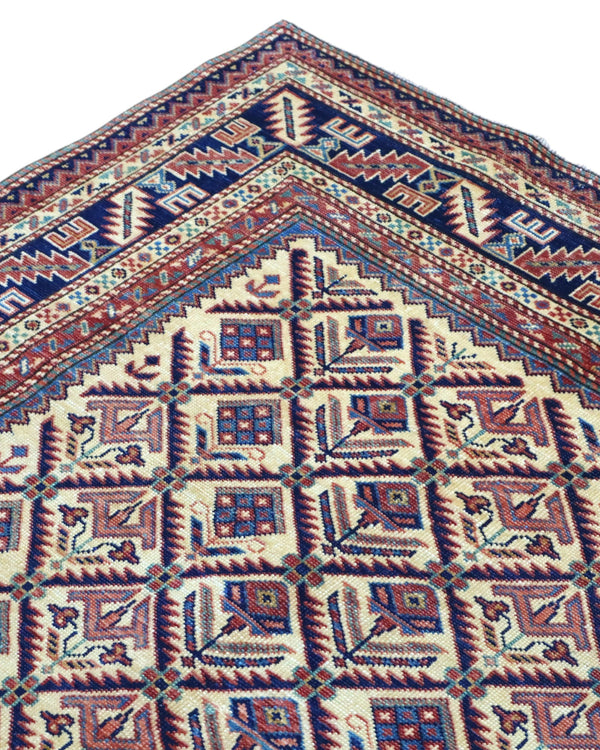 Tappeto Shirvan 166x120 cm in lana annodata a mano, fondo chiaro con rombi geometrici e cornici caucasiche.