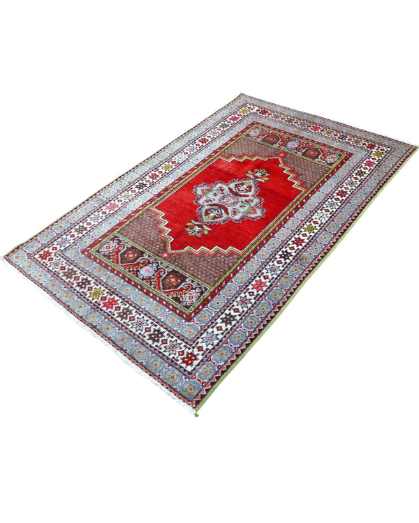 Tappeto Turco 170x108 cm annodato a mano, con campo rosso, medaglione bianco centrale e bordo riccamente decorato.