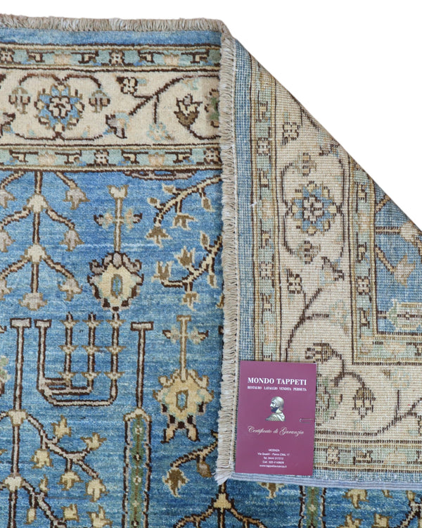 Tappeto Ziegler 188x123 cm con disegno floreale su fondo azzurro e bordura beige, perfetto per arredamenti eleganti e moderni.