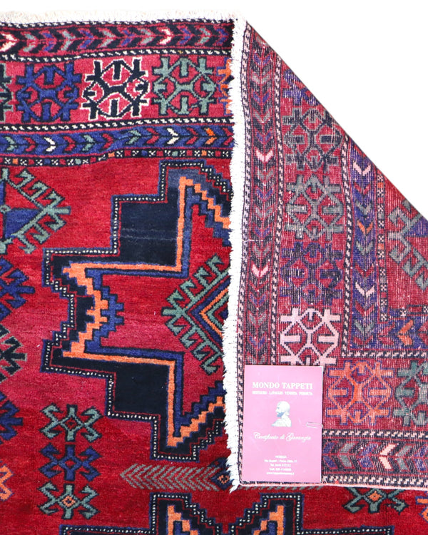 Tappeto Hamadan 214x131 cm in lana annodata a mano, con motivi a stelle geometriche su fondo rosso e cornice tribale.