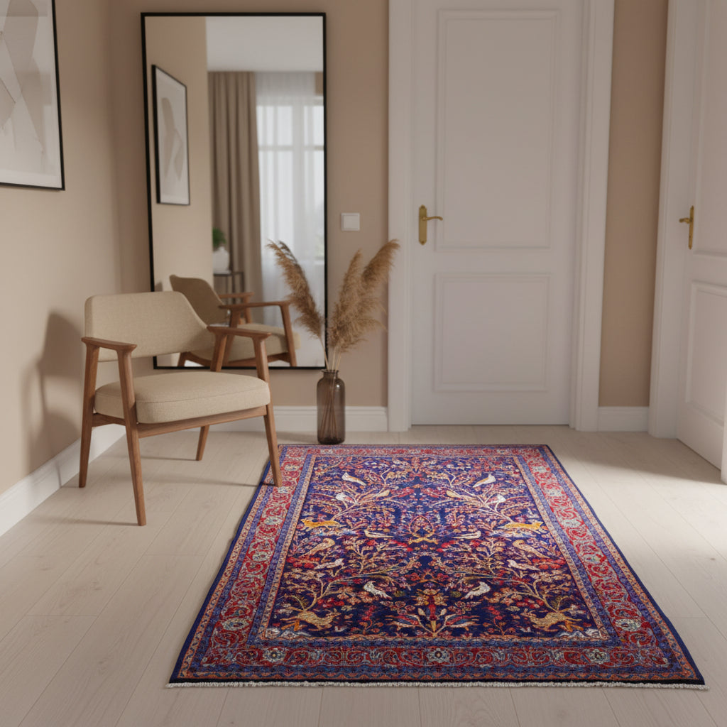 Tappeto Arak 210x126 cm persiano annodato a mano, con motivi floreali e animali su fondo blu intenso e cornice rossa decorata.