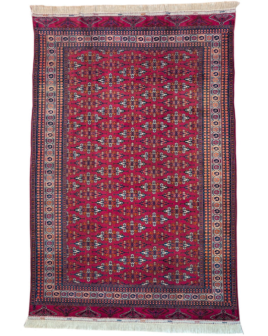 Tappeto Bokhara 280x180 cm con fondo rosso intenso e motivi geometrici blu, nero e avorio, tramato ed annodato a mano, provenienza Asia Centrale.