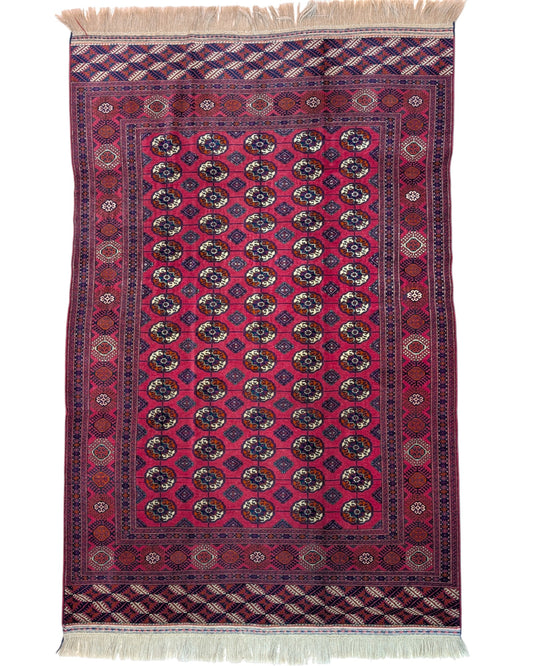 Tappeto Bukhara 278x180 cm con fondo rosso e motivi a gul in nero e avorio, tramato ed annodato a mano, provenienza Asia Centrale.