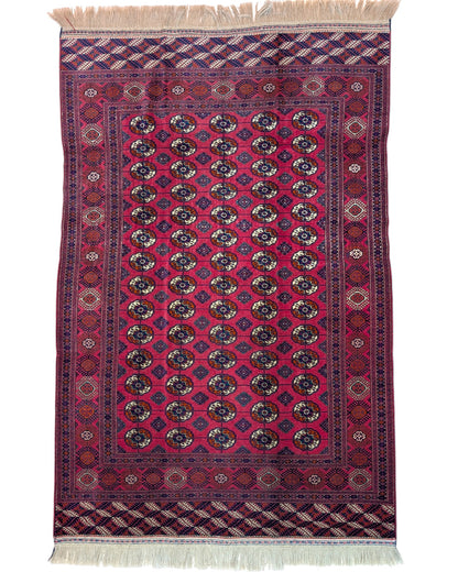 Tappeto Bukhara 278x180 cm con fondo rosso e motivi a gul in nero e avorio, tramato ed annodato a mano, provenienza Asia Centrale.