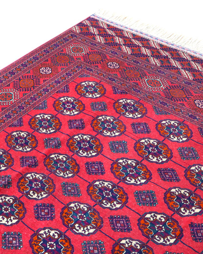 Tappeto Bukhara 278x180 cm con fondo rosso e motivi a gul in nero e avorio, tramato ed annodato a mano, provenienza Asia Centrale.