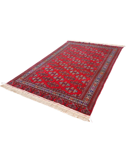 Tappeto Bukhara 280x180 cm con fondo rosso rubino e motivi geometrici ripetuti, tramato ed annodato a mano, provenienza Asia Centrale.