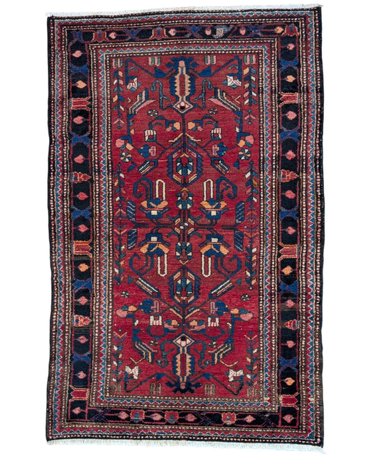 Tappeto Hamedan 200x130 cm persiano, rettangolare, annodato a mano, fondo rosso con motivi geometrici e floreali blu e avorio, bordi decorati.