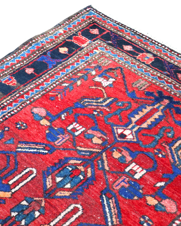 Tappeto Hamedan 200x130 cm persiano, rettangolare, annodato a mano, fondo rosso con motivi geometrici e floreali blu e avorio, bordi decorati.