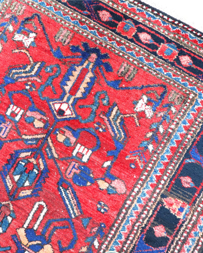 Tappeto Hamedan 200x130 cm persiano, rettangolare, annodato a mano, fondo rosso con motivi geometrici e floreali blu e avorio, bordi decorati.