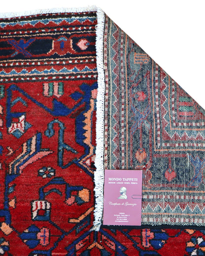 Tappeto Hamedan 200x130 cm persiano, rettangolare, annodato a mano, fondo rosso con motivi geometrici e floreali blu e avorio, bordi decorati.