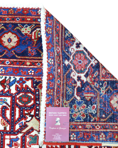 Tappeto Heriz persiano 336x248 cm, annodato a mano in lana e cotone, con medaglione geometrico e motivi floreali tradizionali.