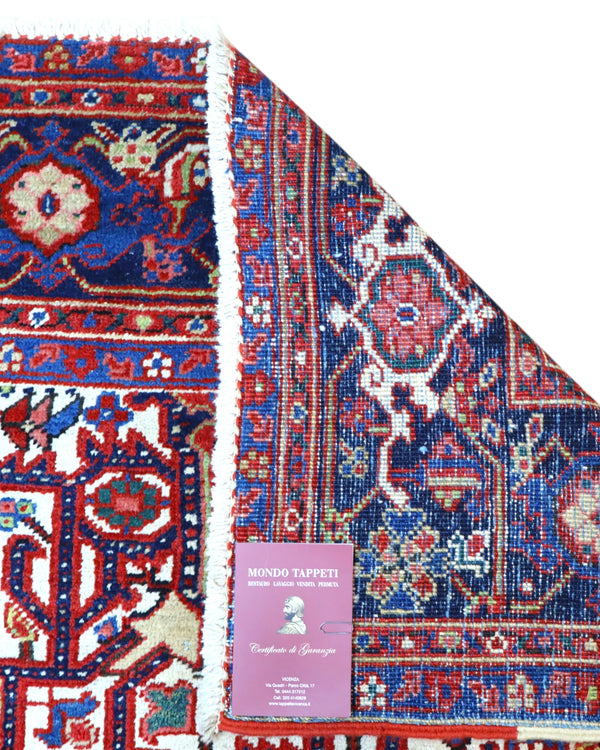 Tappeto Heriz persiano 336x248 cm, annodato a mano in lana e cotone, con medaglione geometrico e motivi floreali tradizionali.