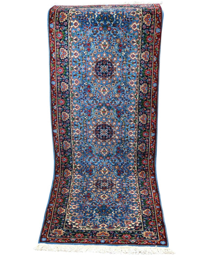 Tappeto Kerman 186x62 cm annodato a mano con fondo azzurro e cornice scura.