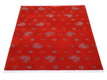Tappeto moderno 148x107 cm annodato a mano in Persia, fondo rosso con motivi floreali stilizzati, lana e colori vegetali.