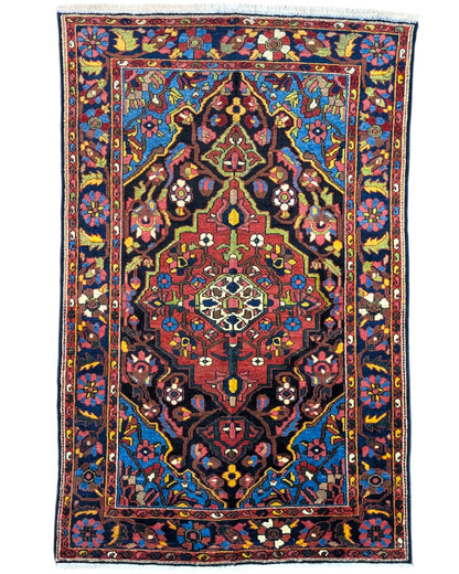 Tappeto Nahavand "Giardino Persiano" blu con motivi floreali e geometrici, annodato a mano in Persia con lana e cotone tinti con colori vegetali.