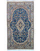 Tappeto Nain 208x120 cm persiano, annodato a mano, fondo blu con medaglione centrale avorio e motivi floreali in lana e seta.