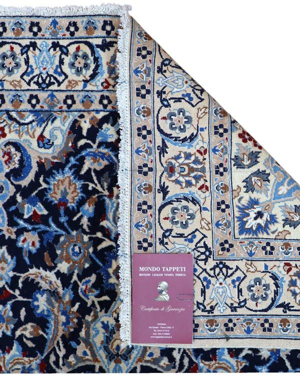 Tappeto Nain 9 fili 191x120 cm annodato a mano, rettangolare, in lana e cotone con colori vegetali, design floreale persiano su fondo blu scuro.