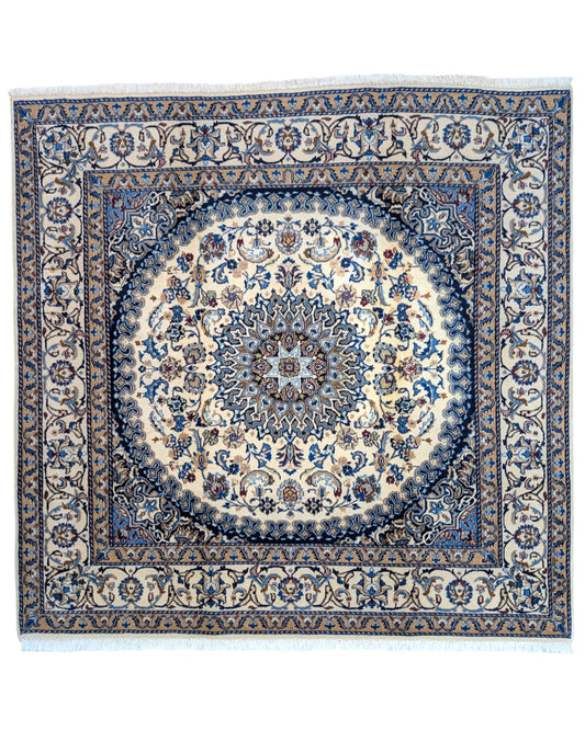 Tappeto Nain con medaglione floreale stilizzato su fondo beige e dettagli celesti, annodato a mano in Persia con lana mista seta e cotone.