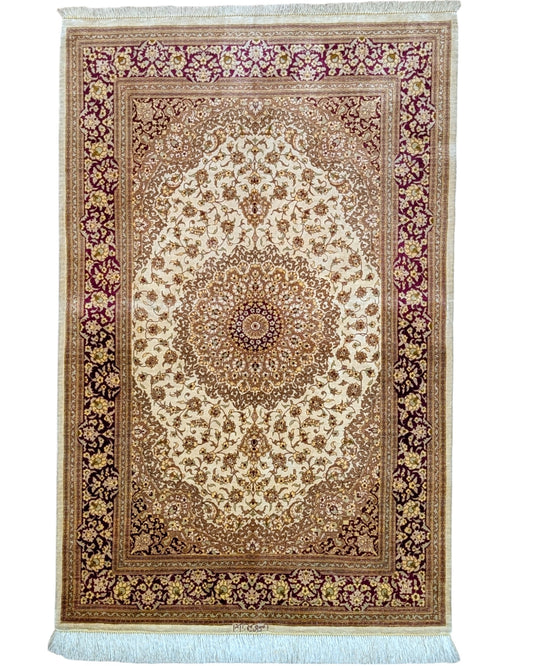 Tappeto Qum in pura seta 155x100 cm, annodato a mano in Persia, fondo oro con motivi decorativi raffinati, seta tinta vegetale, certificato incluso.