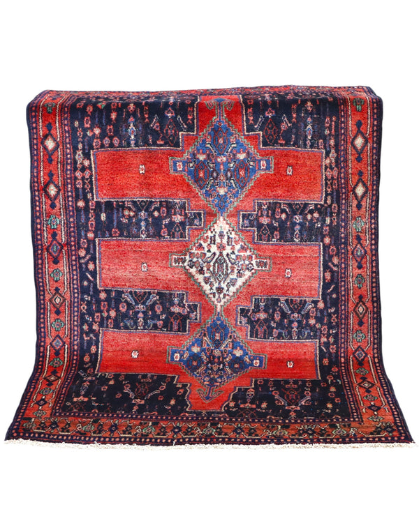 Tappeto Senneh 175x124 cm persiano, annodato a mano, fondo rosso con tre medaglioni geometrici blu e avorio, motivi floreali stilizzati.