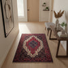 Tappeto Senneh 174x122 cm, annodato a mano, con grande medaglione geometrico centrale e motivi floreali su campo rosso e blu.