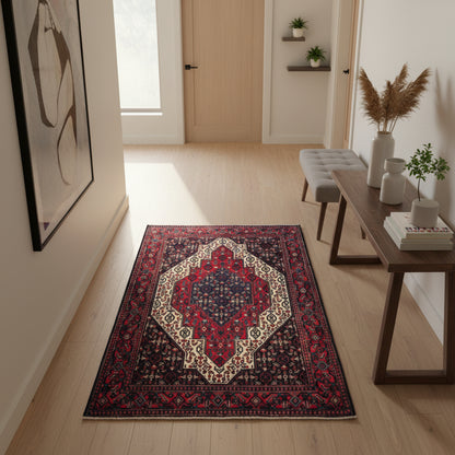 Tappeto Senneh 174x122 cm, annodato a mano, con grande medaglione geometrico centrale e motivi floreali su campo rosso e blu.