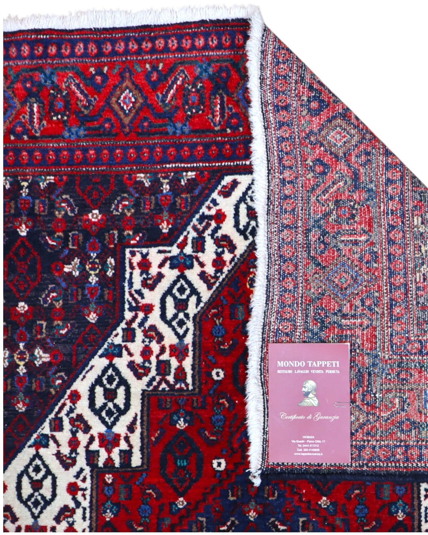 Tappeto Senneh 174x122 cm, annodato a mano, con grande medaglione geometrico centrale e motivi floreali su campo rosso e blu.