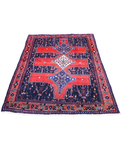 Tappeto Senneh 175x124 cm persiano, annodato a mano, fondo rosso con tre medaglioni geometrici blu e avorio, motivi floreali stilizzati.