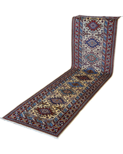 Tappeto Shirvan annodato a mano 301x83 cm in lana con fondo beige, cornice rossa e motivi geometrici tradizionali afgani.