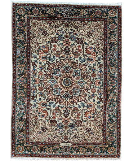 Tappeto Transilvania 180x130 cm annodato a mano, rettangolare, in lana e cotone, fondo avorio con medaglione centrale marrone e motivi floreali in verde, azzurro e rosso.