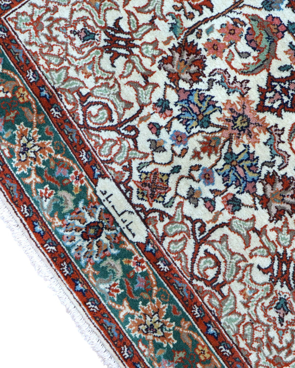 Tappeto Transilvania 180x130 cm annodato a mano, rettangolare, in lana e cotone, fondo avorio con medaglione centrale marrone e motivi floreali in verde, azzurro e rosso.