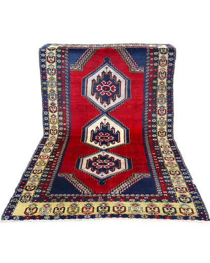 Tappeto Turko 273x149 cm annodato a mano, rettangolare, fondo rosso intenso con tre medaglioni geometrici blu e avorio, cornice decorata con motivi anatolici.