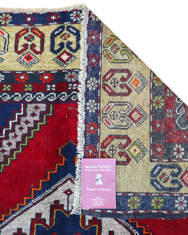 Tappeto Turko 273x149 cm annodato a mano, rettangolare, fondo rosso intenso con tre medaglioni geometrici blu e avorio, cornice decorata con motivi anatolici.