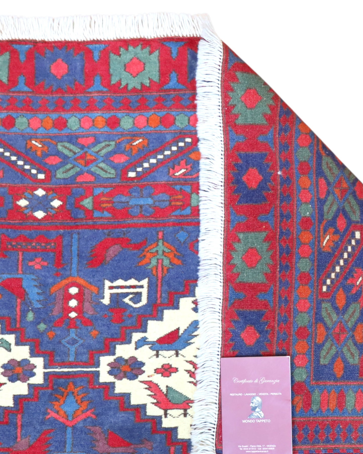 Tappeto afgano 289x196 cm con fondo blu e motivi geometrici avorio e rossi, tramato ed annodato a mano, provenienza Afghanistan.