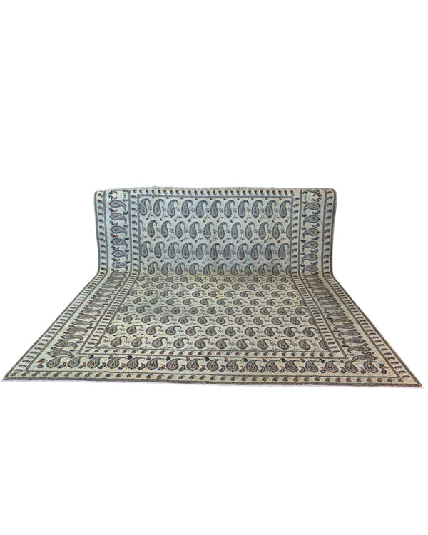 Tappeto persiano Kashan 375x280 cm, fondo beige con motivi paisley stilizzati blu e marrone, annodato a mano in lana vegetale.