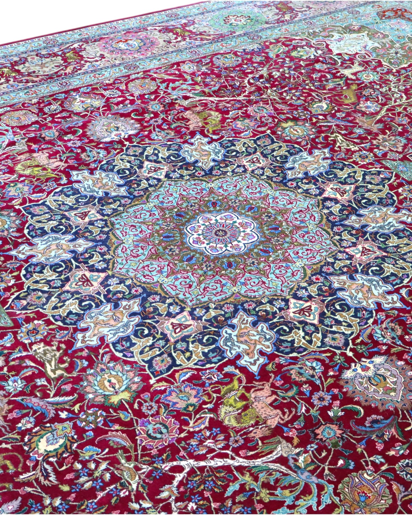 Tappeto persiano Tabriz 60Rag 424x294 cm, fondo rosso e blu con ampio medaglione e cornice verde, annodato a mano in seta e lana vegetale.