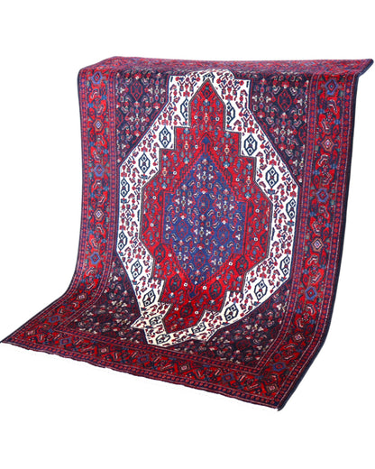 Tappeto Senneh 174x122 cm, annodato a mano, con grande medaglione geometrico centrale e motivi floreali su campo rosso e blu.