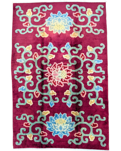 Tappeto tibetano annodato a mano 232x153cm con motivi floreali stilizzati multicolore su fondo bordeaux.
