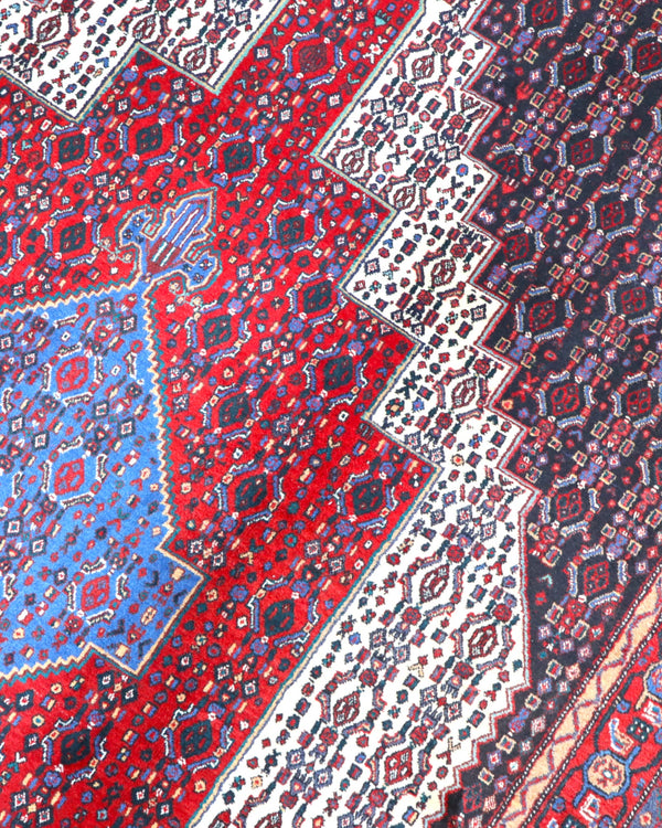 "Tappeto Sannhe annodato a mano con motivi geometrici e floreali in rosso, blu e bianco, 300x200 cm."