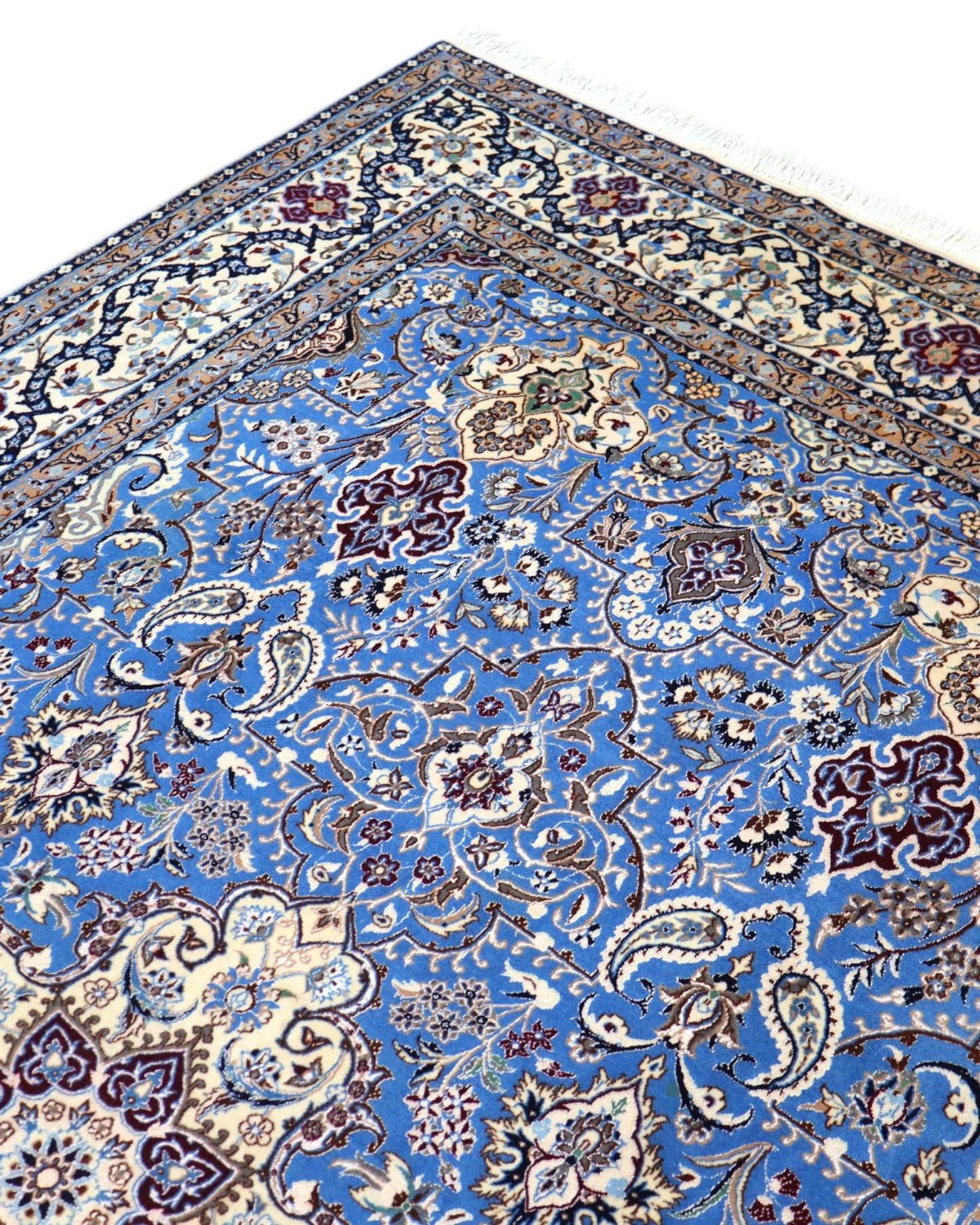 "Tappeto Nain annodato a mano con motivi floreali in beige, avorio e viola su fondo blu, 310x203 cm."