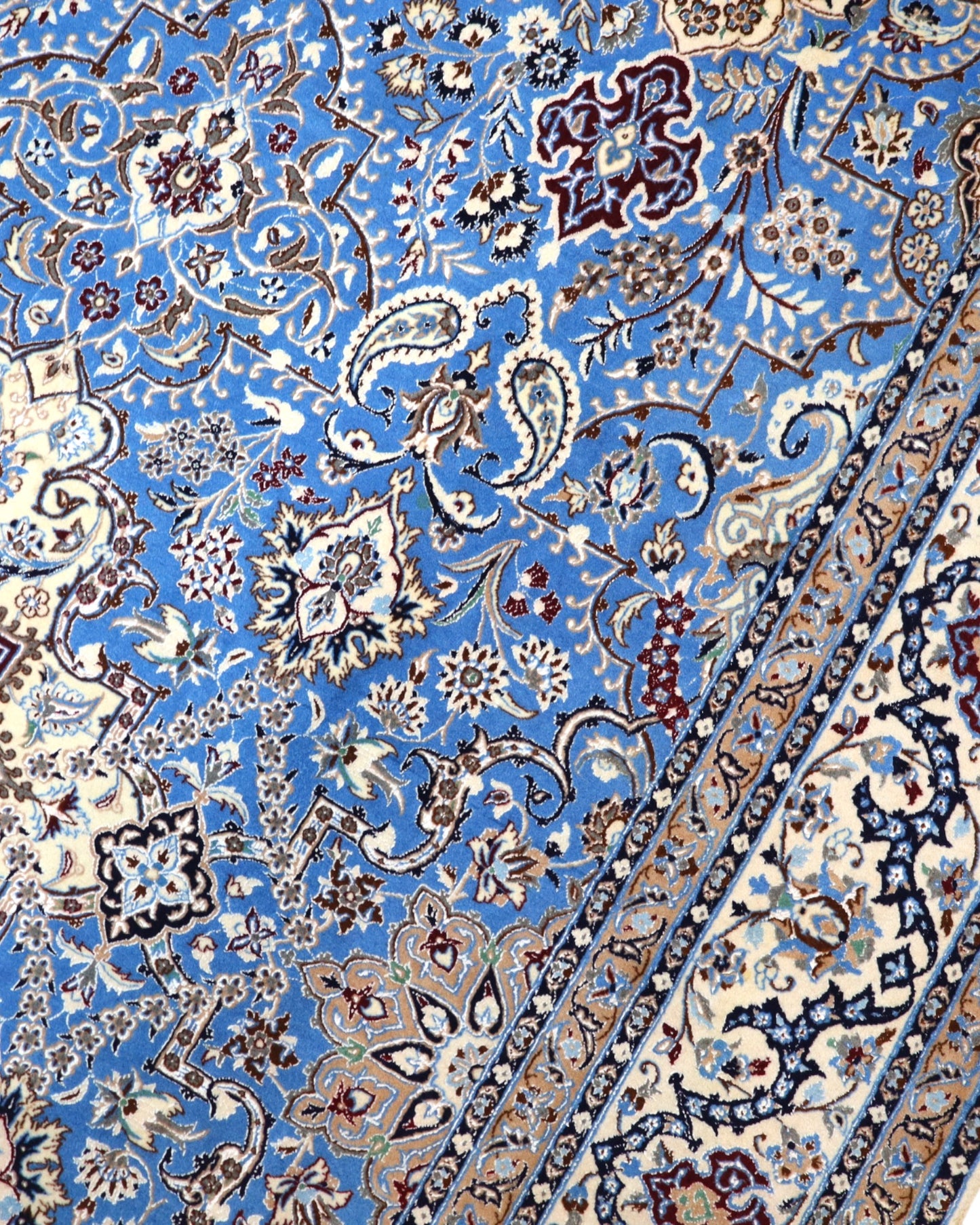 "Tappeto Nain annodato a mano con motivi floreali in beige, avorio e viola su fondo blu, 310x203 cm."