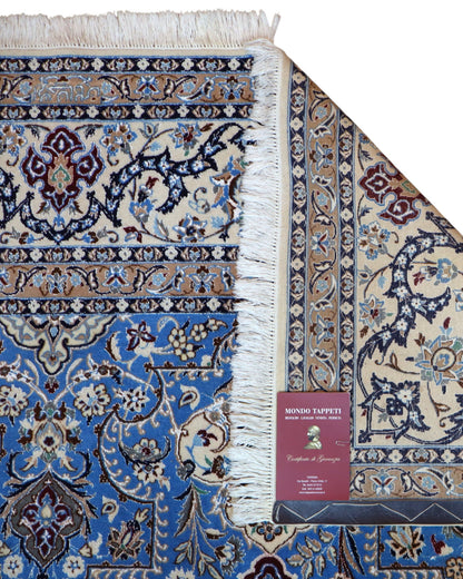 "Tappeto Nain annodato a mano con motivi floreali in beige, avorio e viola su fondo blu, 310x203 cm."