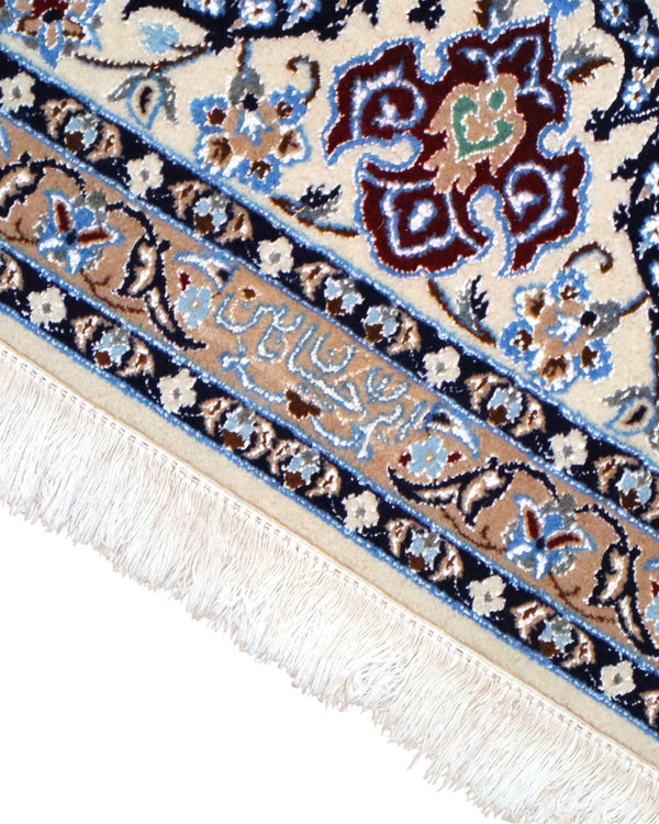 "Tappeto Nain annodato a mano con motivi floreali in beige, avorio e viola su fondo blu, 310x203 cm."