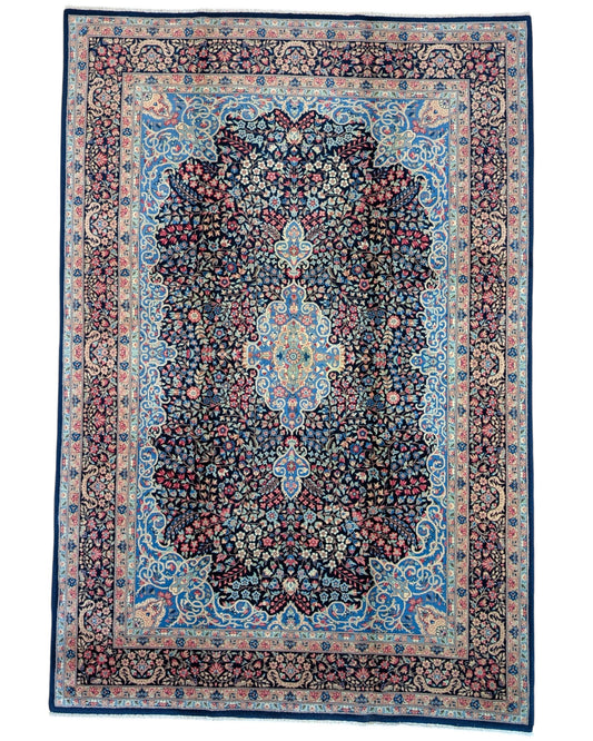 "Tappeto Kerman annodato a mano con motivi floreali in rosso, blu e avorio su fondo blu, 280x189 cm."