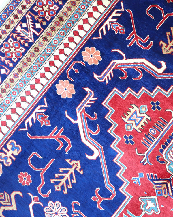 Tappeto Shirvan 317x224 cm con fondo blu, medaglione rosso e dettagli geometrici avorio e giallo, tramato ed annodato a mano, provenienza Caucaso.