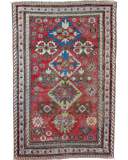 Tappeto caucasico antico 166x110 cm rosso con motivi geometrici in soggiorno elegante