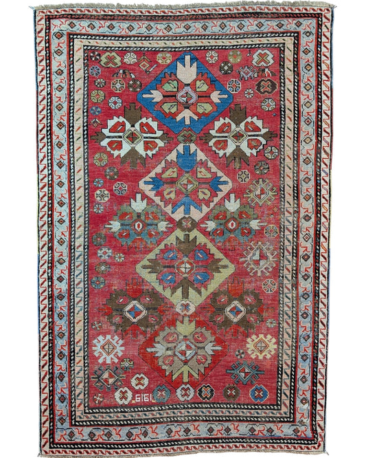 Tappeto caucasico antico 166x110 cm rosso con motivi geometrici in soggiorno elegante